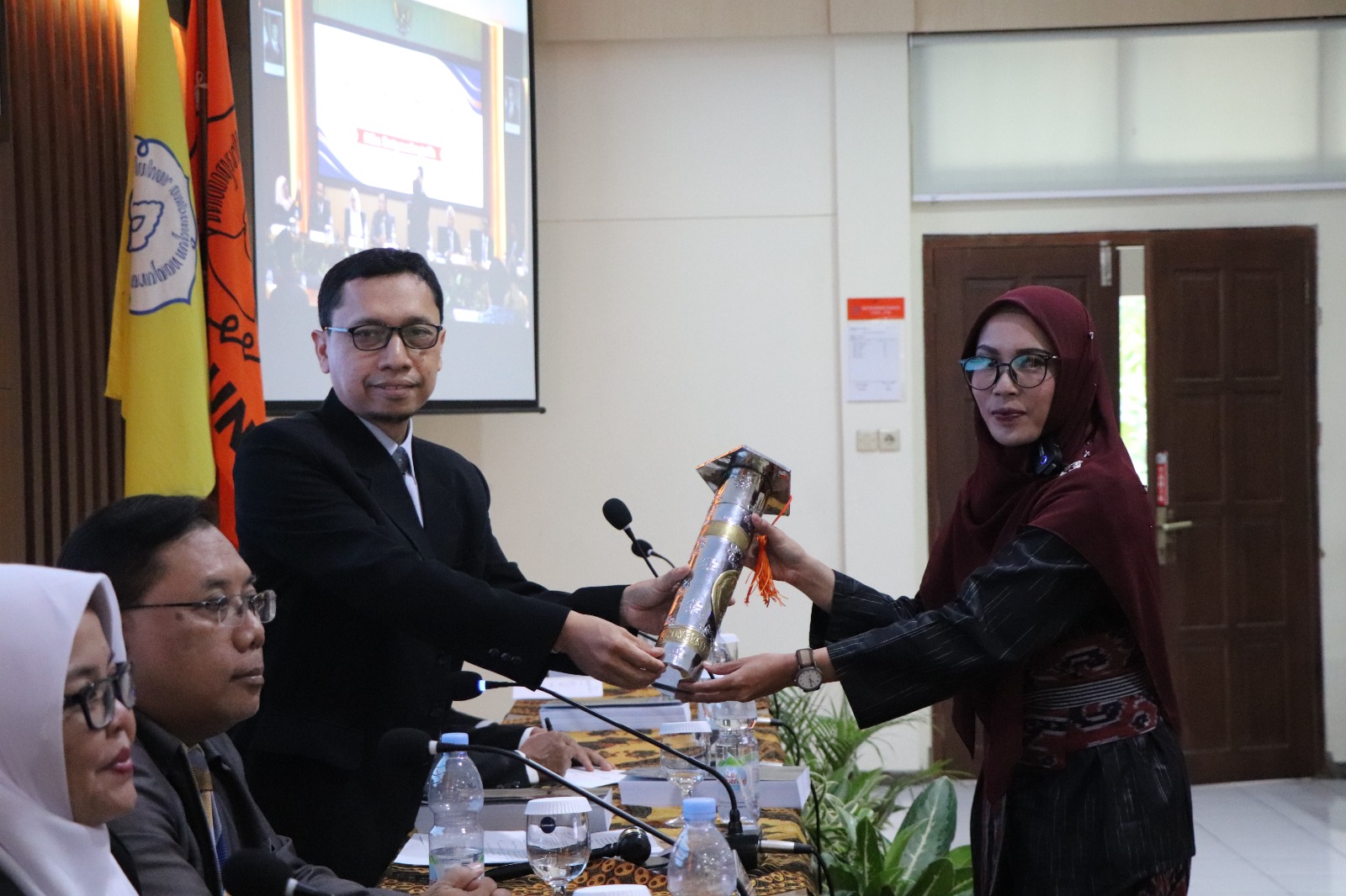 Rila Setyaningsih menerima simbolis kelulusan ujian terbuka